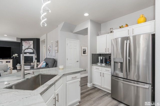 450 Ruffian Ct, Reno, NV 89521 - kitchen featuring stainless steel fridge, a sink, open floor plan, light stone countertops, and white cabinetry