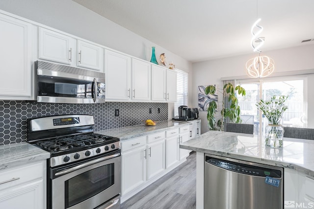 450 Ruffian Ct, Reno, NV 89521 - kitchen with appliances with stainless steel finishes, white cabinetry, backsplash, light wood-style floors, and light stone countertops