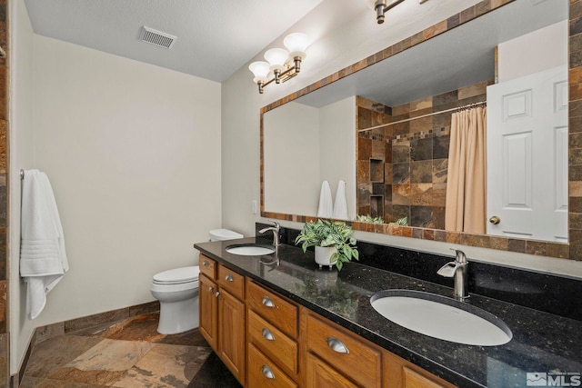 2116 Frisco Way, Sparks, NV 89434 - full bath featuring stone tile floors, toilet, tiled shower, baseboards, and double vanity