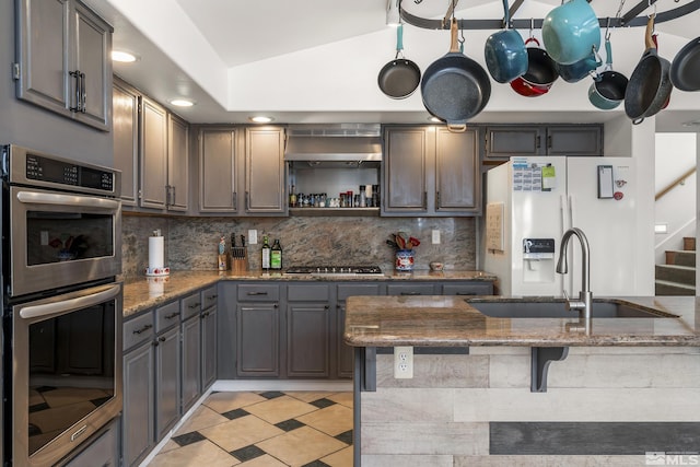 960 Country Ridge Dr, Sparks, NV 89434 - kitchen with a sink, appliances with stainless steel finishes, decorative backsplash, lofted ceiling, and stone counters