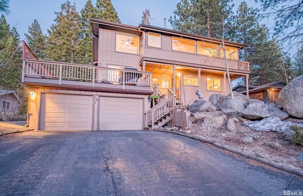 191 Hall Ct, Stateline, NV 89449 - view of front of home with asphalt driveway, a balcony, stairs, and an attached garage