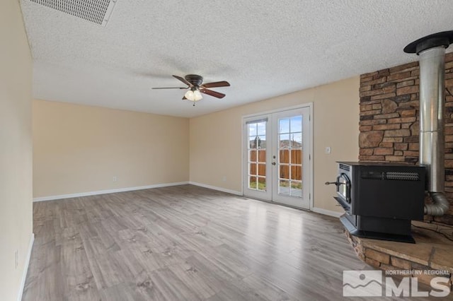 68 Zircon Dr, Reno, NV 89521 - unfurnished living room with a wood stove, a textured ceiling, ceiling fan, wood finished floors, and baseboards