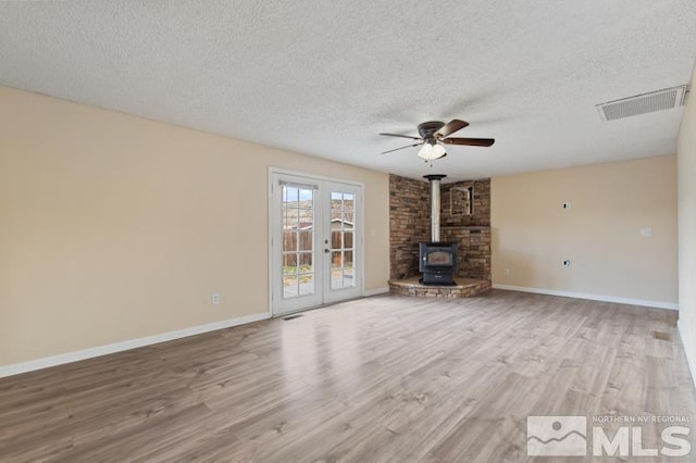 68 Zircon Dr, Reno, NV 89521 - unfurnished living room with a wood stove, a textured ceiling, wood finished floors, ceiling fan, and baseboards