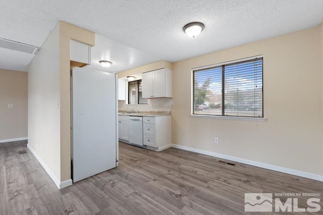 68 Zircon Dr, Reno, NV 89521 - kitchen featuring wood finished floors, light countertops, dishwasher, white cabinetry, and a textured ceiling
