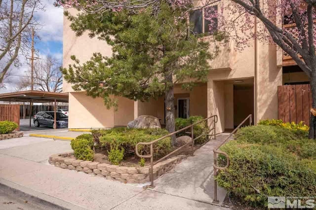 2700 Plumas St Unit 300, Reno, NV 89509 - view of front facade featuring stucco siding, fence, and covered parking