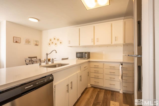 2700 Plumas St Unit 300, Reno, NV 89509 - kitchen featuring appliances with stainless steel finishes, a sink, light countertops, and dark wood-type flooring