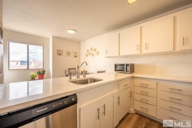 2700 Plumas St Unit 300, Reno, NV 89509 - kitchen featuring a sink, appliances with stainless steel finishes, light countertops, and dark wood finished floors