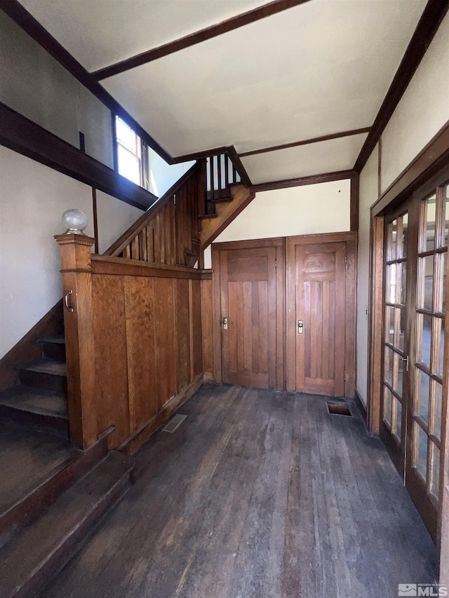 215 S Broad St, Battle Mountain, NV 89820 - unfurnished living room with stairs, dark wood-style flooring, french doors, and wooden walls