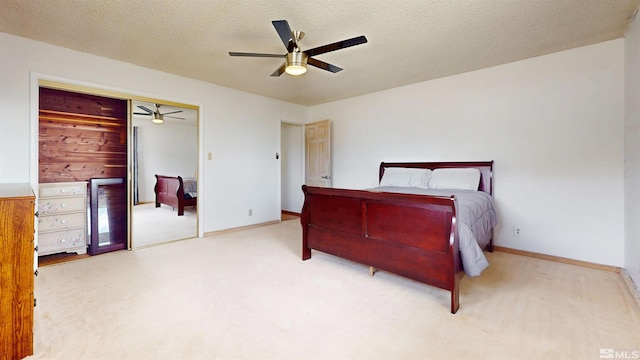 bedroom featuring carpet, wine cooler, a closet, a textured ceiling, and baseboards