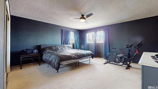 bedroom with carpet flooring, a textured ceiling, a textured wall, and a ceiling fan