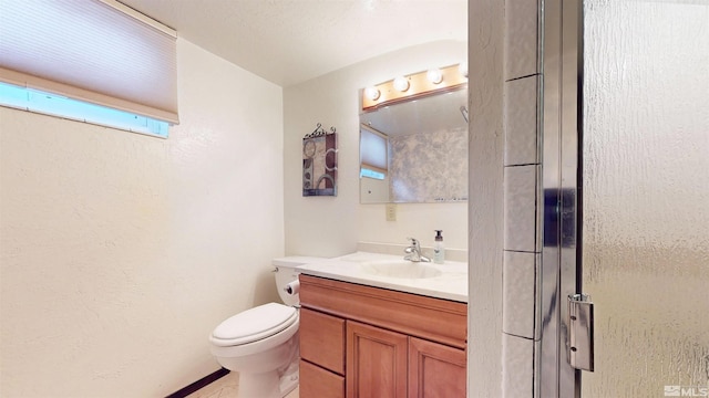 bathroom featuring vanity, toilet, and baseboards