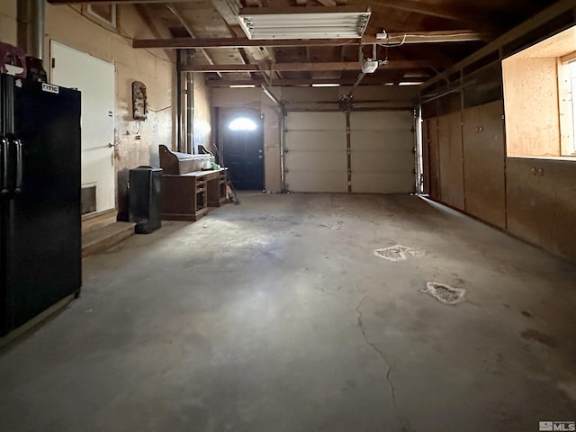 garage with freestanding refrigerator and a garage door opener