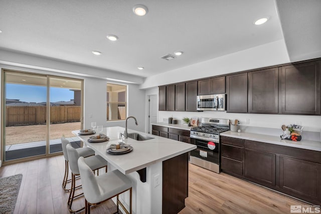 15 Nova Ct Unit 112, Carson City, NV 89705 - kitchen with stainless steel appliances, a sink, a kitchen breakfast bar, light countertops, and light wood-style flooring