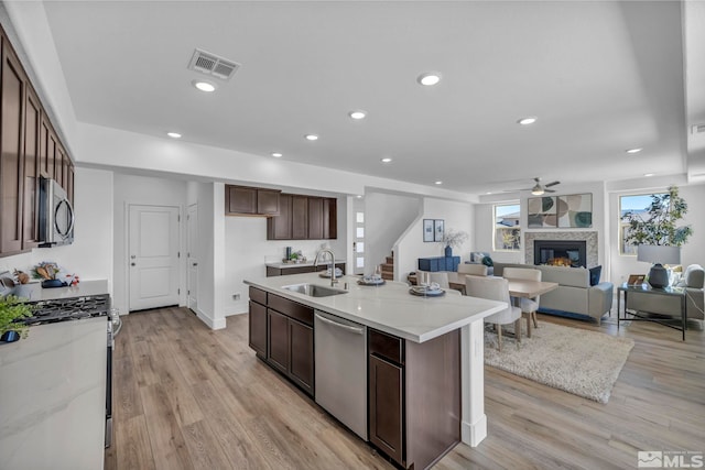 15 Nova Ct Unit 112, Carson City, NV 89705 - kitchen featuring appliances with stainless steel finishes, a sink, a glass covered fireplace, a ceiling fan, and light wood finished floors