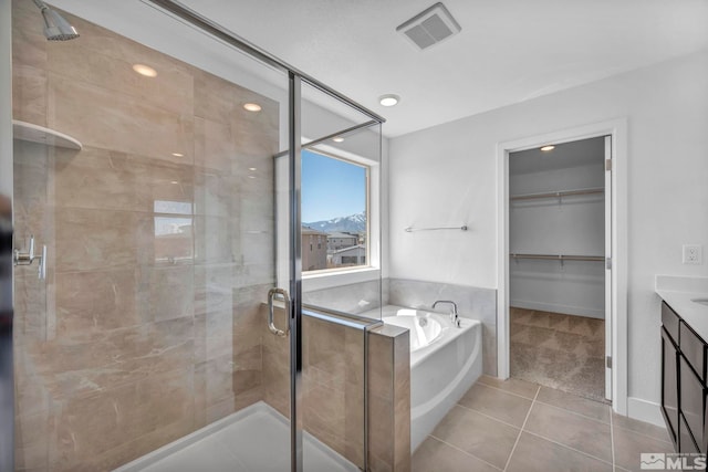 15 Nova Ct Unit 112, Carson City, NV 89705 - bathroom with a bath, tile patterned flooring, a stall shower, a spacious closet, and vanity