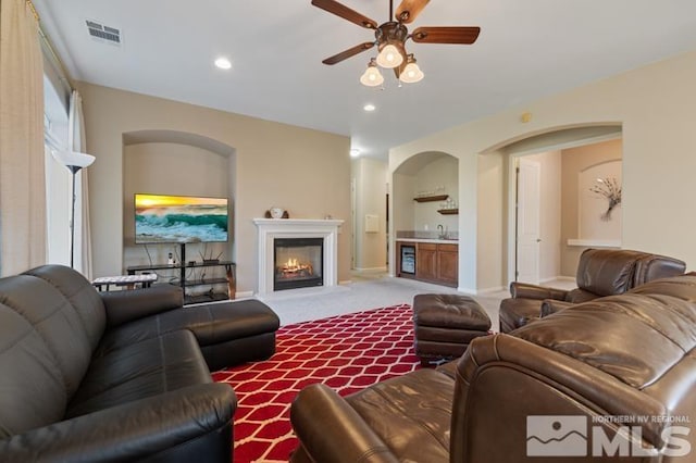 9900 Wilbur May Pkwy Unit 2704, Reno, NV 89521 - living area with ceiling fan, carpet floors, a warm lit fireplace, recessed lighting, and arched walkways