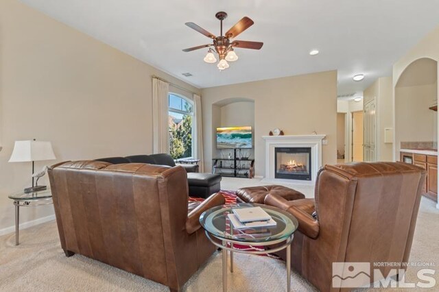 9900 Wilbur May Pkwy Unit 2704, Reno, NV 89521 - living area with light carpet, ceiling fan, baseboards, and a glass covered fireplace