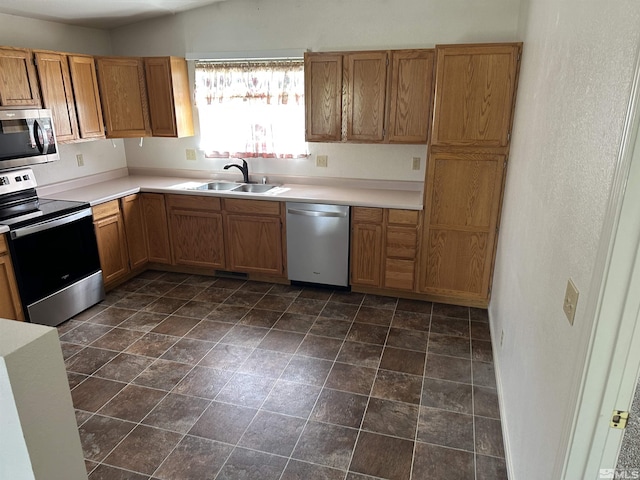 1755 Jamie Way, Carson City, NV 89701 - kitchen featuring appliances with stainless steel finishes, a sink, light countertops, and brown cabinets