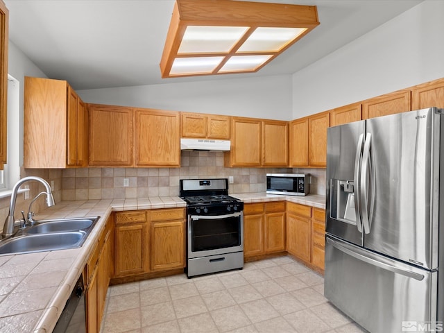 1564 Reese River Rd, Fernley, NV 89408 - kitchen with appliances with stainless steel finishes, under cabinet range hood, a sink, tile counters, and tasteful backsplash