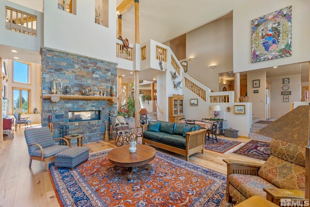 180 Nottingham Ct, Reno, NV 89511 - living room with a towering ceiling, wood-type flooring, stairs, and a stone fireplace
