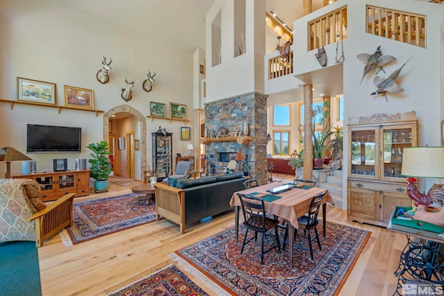 180 Nottingham Ct, Reno, NV 89511 - dining space with a high ceiling, wood finished floors, arched walkways, and a stone fireplace