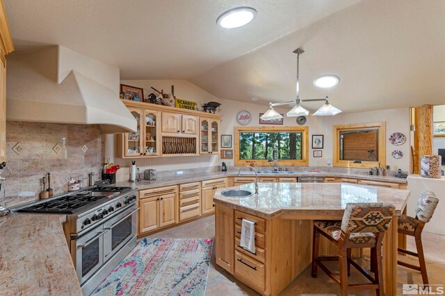 180 Nottingham Ct, Reno, NV 89511 - kitchen with double oven range, a sink, vaulted ceiling, a kitchen island with sink, and decorative backsplash
