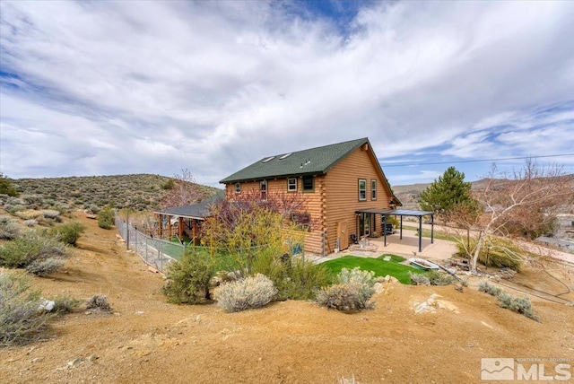 8705 Spearhead Way, Reno, NV 89506 - rear view of property featuring log siding, a patio area, and fence
