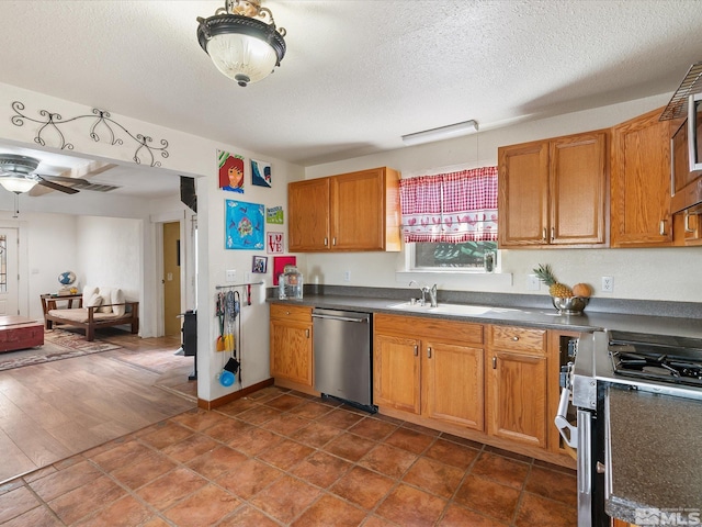 325 Stock Ln, Fernley, NV 89408 - kitchen with appliances with stainless steel finishes, a sink, dark countertops, brown cabinetry, and a textured ceiling