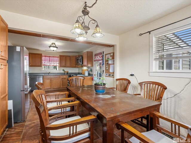 325 Stock Ln, Fernley, NV 89408 - dining room with a textured ceiling, dark tile patterned floors, and a chandelier