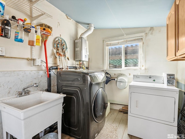 325 Stock Ln, Fernley, NV 89408 - washroom with cabinet space, washing machine and dryer, water heater, and light wood-style floors