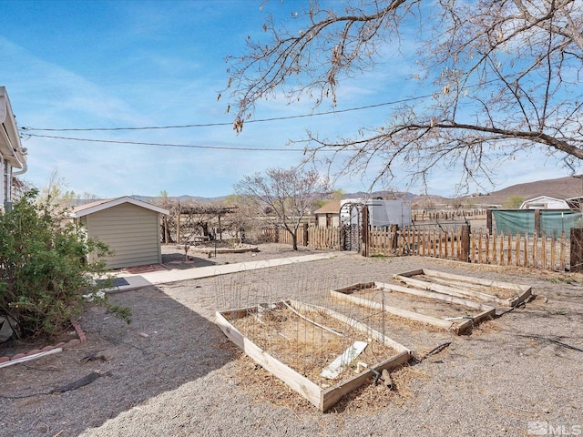 325 Stock Ln, Fernley, NV 89408 - view of yard featuring a vegetable garden, fence, an outbuilding, and a shed