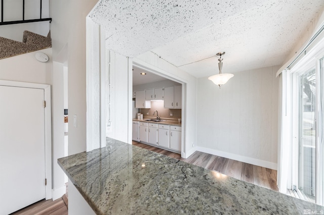2271 Oppio St, Sparks, NV 89431 - kitchen featuring a sink, light wood-style flooring, white cabinetry, baseboards, and pendant lighting