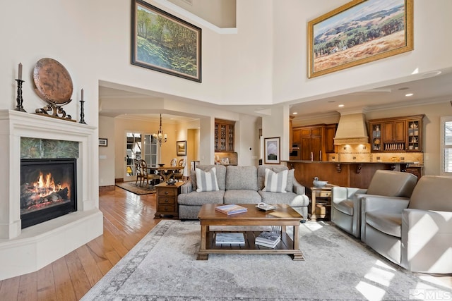 6554 Champetre, Reno, NV 89511 - living room with light wood-style flooring, a chandelier, crown molding, a fireplace, and a high ceiling