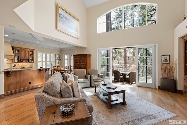6554 Champetre, Reno, NV 89511 - living area with light wood-style floors, a towering ceiling, a chandelier, and crown molding