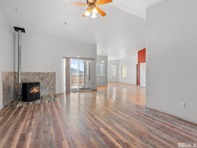 1974 Spring Rd, Fernley, NV 89408 - unfurnished living room featuring wood finished floors, a ceiling fan, and a wood stove