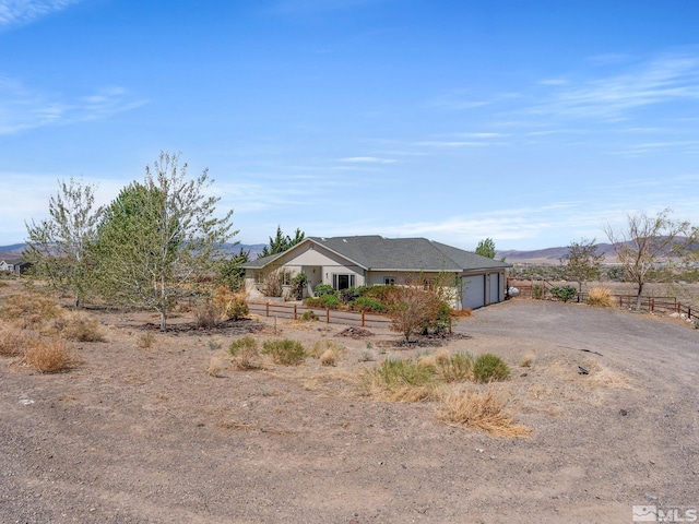 1974 Spring Rd, Fernley, NV 89408 - view of front facade featuring a garage, dirt driveway, and a mountain view