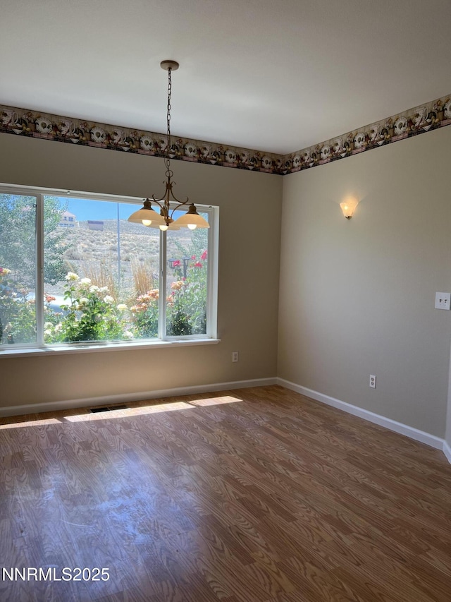 1974 Spring Rd, Fernley, NV 89408 - unfurnished room with healthy amount of natural light, baseboards, a chandelier, and wood finished floors