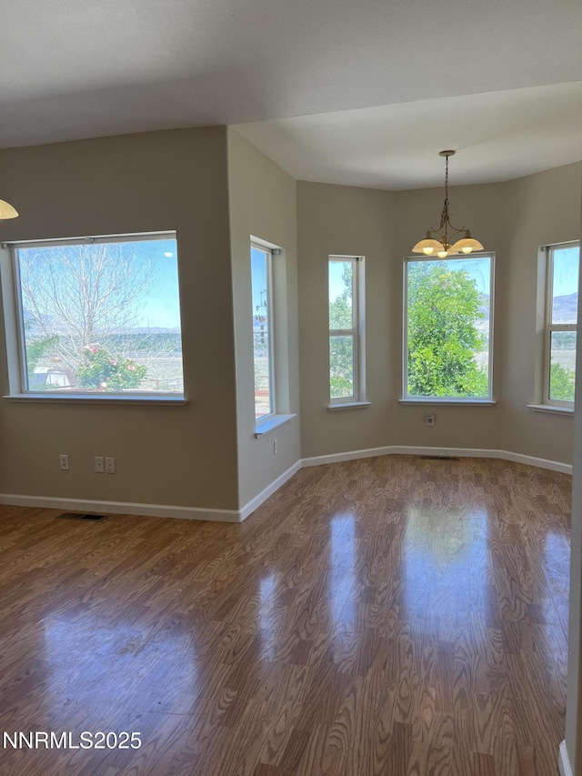 1974 Spring Rd, Fernley, NV 89408 - unfurnished room with wood finished floors, plenty of natural light, baseboards, and a chandelier