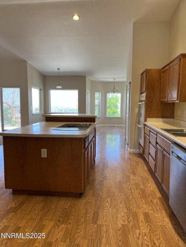1974 Spring Rd, Fernley, NV 89408 - kitchen with dishwasher, electric cooktop, brown cabinetry, light countertops, and recessed lighting