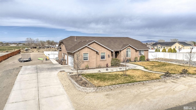 1675 Skyridge Dr, Fallon, NV 89406 - view of front of house with concrete driveway, an attached garage, stucco siding, and a shingled roof