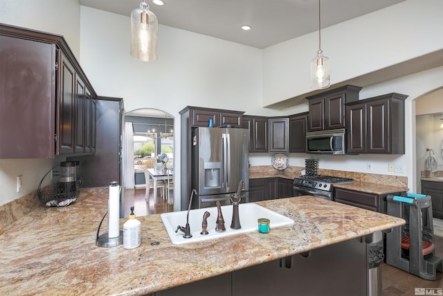 1675 Skyridge Dr, Fallon, NV 89406 - kitchen with appliances with stainless steel finishes, arched walkways, a sink, decorative light fixtures, and a high ceiling