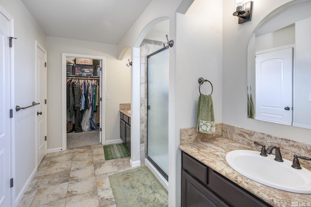 1675 Skyridge Dr, Fallon, NV 89406 - bathroom with vanity, a stall shower, a spacious closet, and baseboards