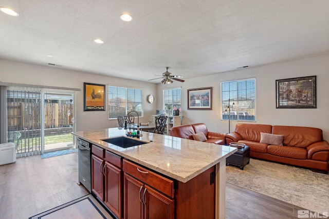 kitchen featuring a sink, light wood finished floors, open floor plan, a ceiling fan, and recessed lighting