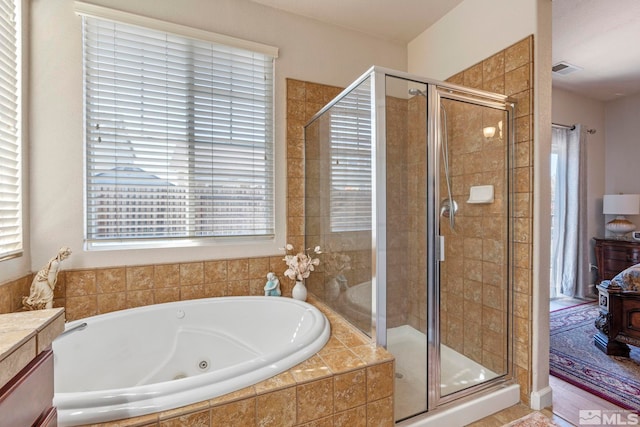 bathroom with healthy amount of natural light, a stall shower, and a whirlpool tub