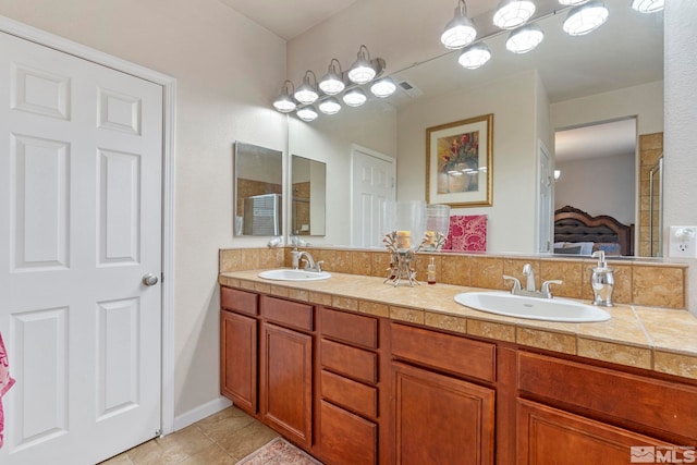 bathroom with connected bathroom, double vanity, and tile patterned flooring