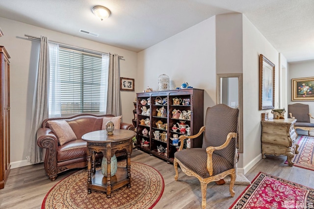 living area featuring light wood-style floors and baseboards