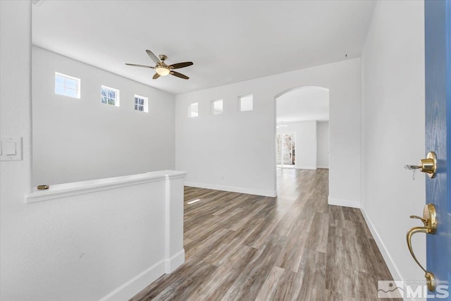 7871 Cantabria Dr, Sparks, NV 89436 - empty room with ceiling fan, arched walkways, and wood finished floors