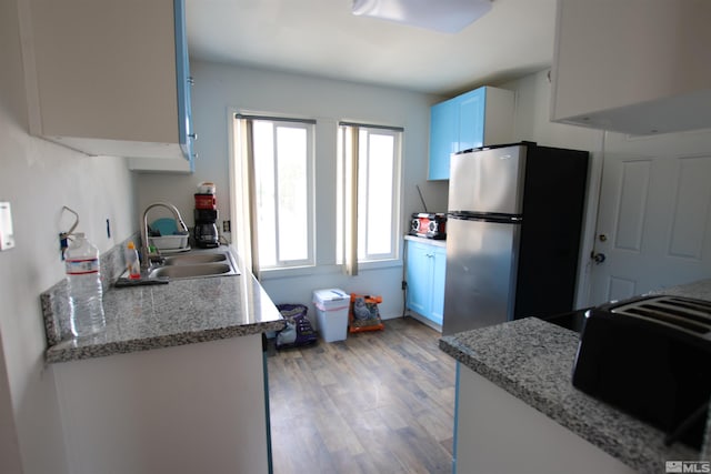 665 C St, Hawthorne, NV 89415 - kitchen with freestanding refrigerator, a sink, and light wood-style floors