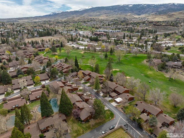view of property location with nearby suburban area, a mountainous background, and a golf course
