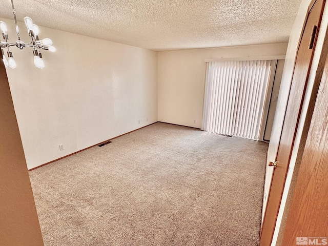 4985 W 7th St Unit 11, Reno, NV 89503 - unfurnished room with carpet flooring, a chandelier, and a textured ceiling